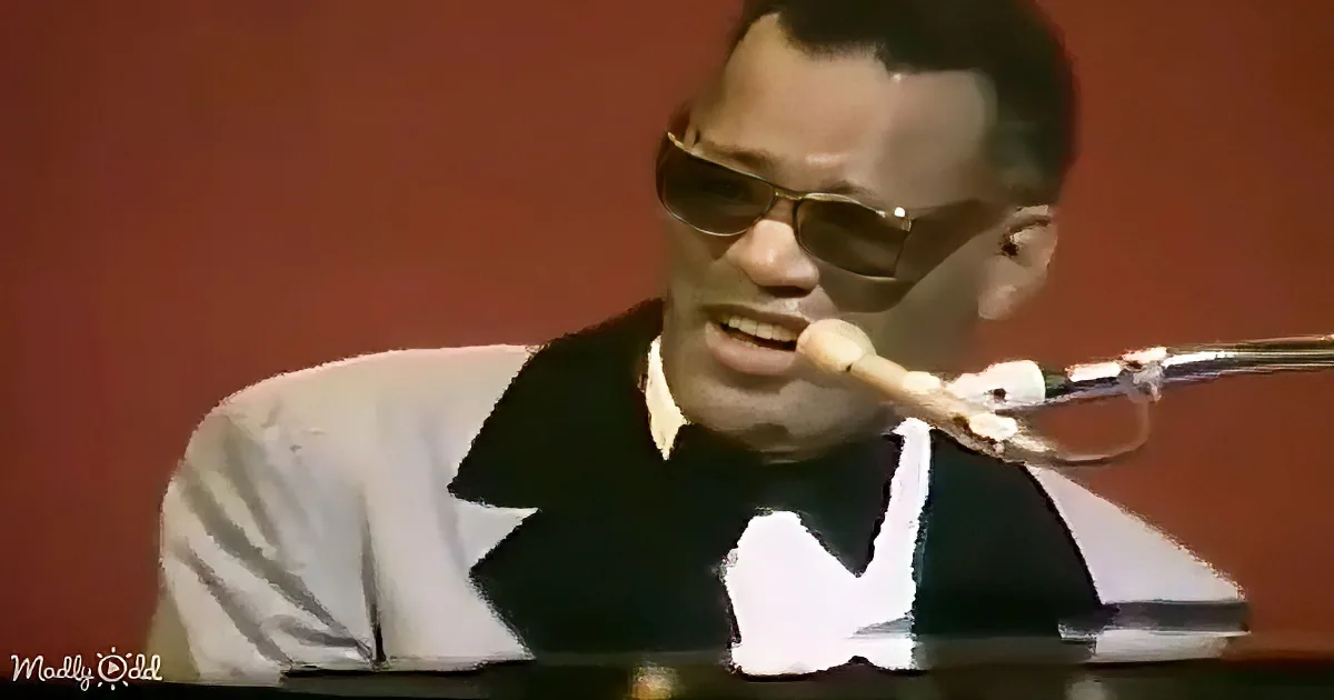 A man in a white and black shirt is playing a trumpet with a red background.