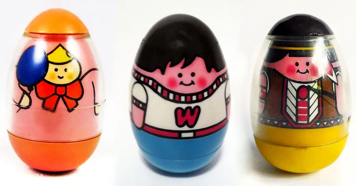 Three colorful plastic eggs with cartoon characters inside, each in different outfits.