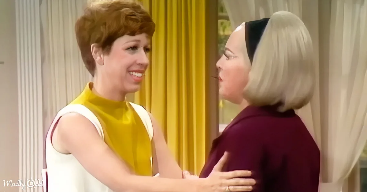 A woman in a yellow and white dress is embracing another woman in a purple dress, both smiling.