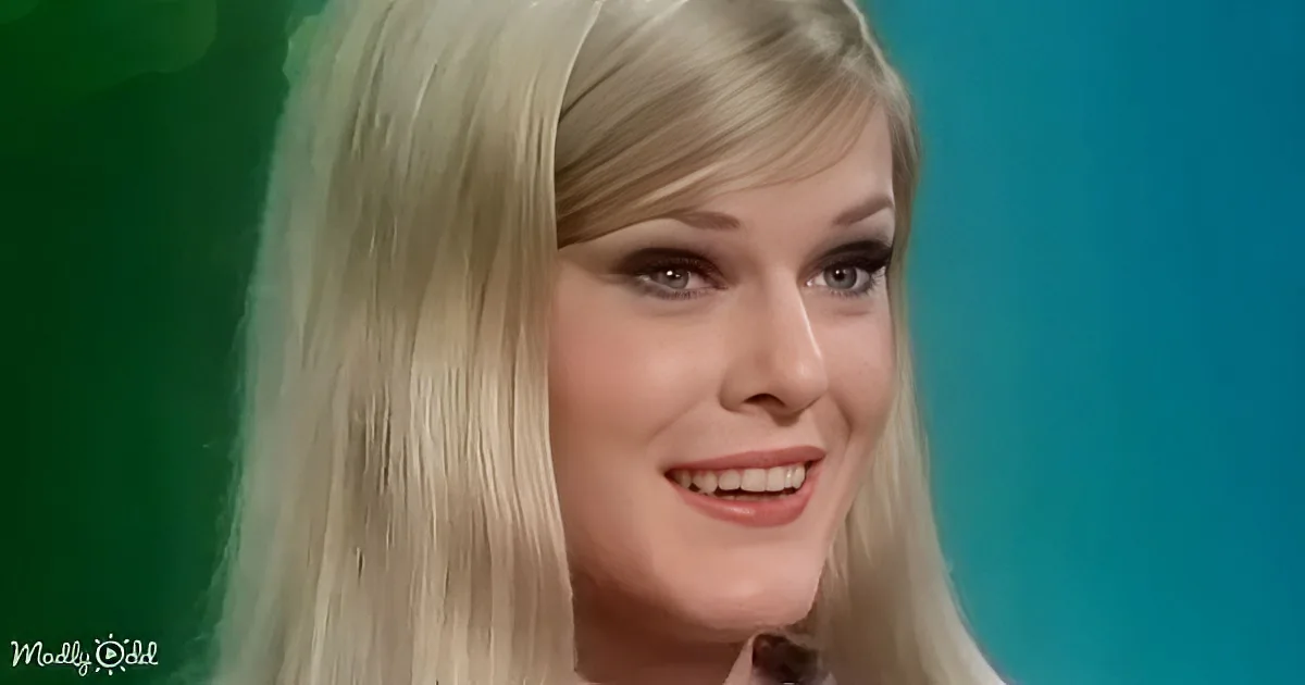 Blonde woman with long hair smiling, green and blue background.