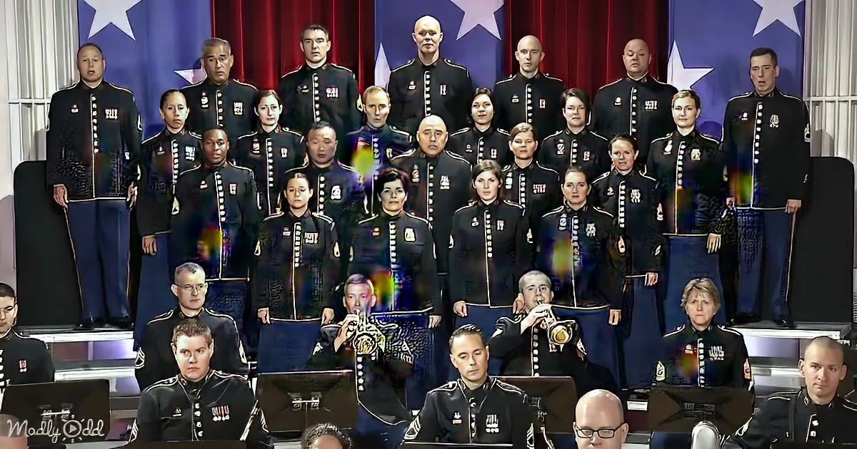 A military band in uniform stands in formation with brass players in the foreground.