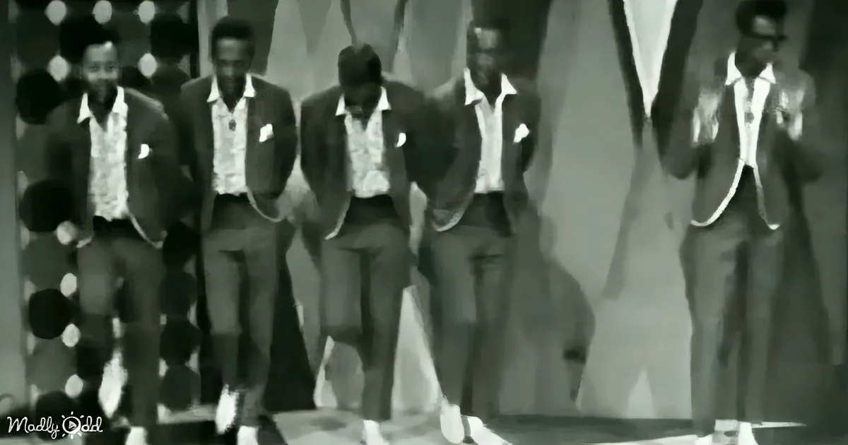 A group of men in suits and hats are performing a synchronized dance routine.