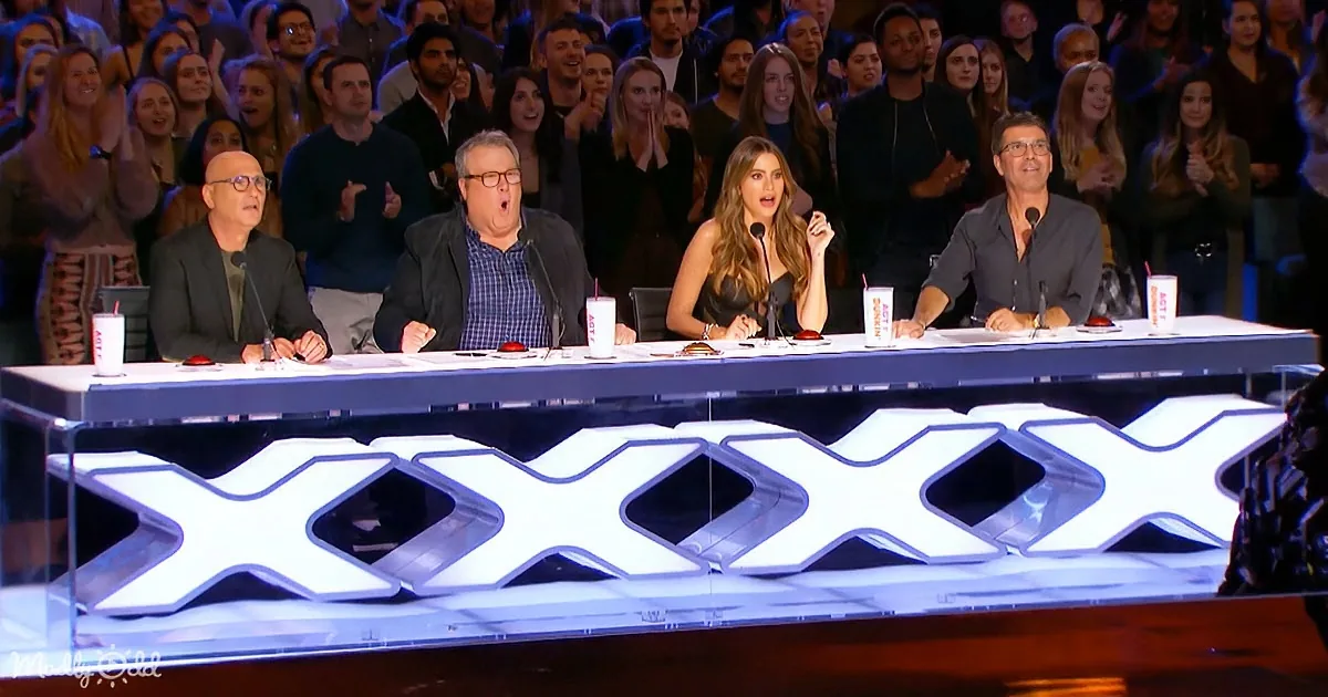 Judges on a panel with "XXX" in front, audience clapping behind them.