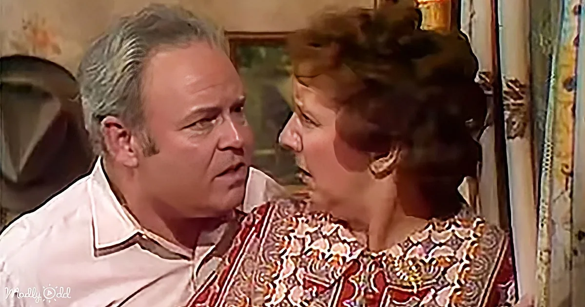 A man and woman are facing each other, seemingly engaged in a conversation, with the woman wearing a patterned dress.