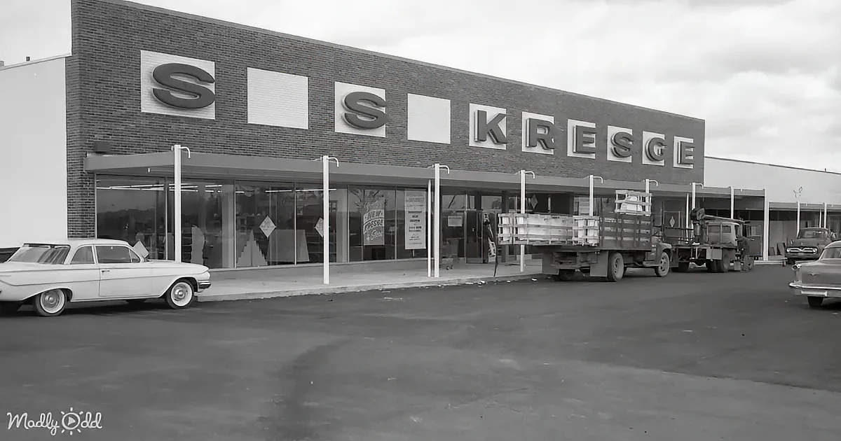 A vintage S.S. Kresge store with a brick facade, large windows, and a truck parked in front.