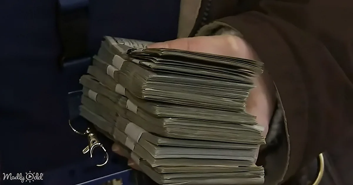 A person holds a large stack of documents with white tape and a keychain.