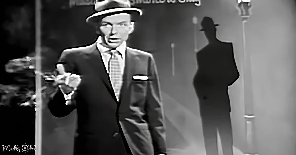 Frank Sinatra in a suit and hat, holding a cigarette, with a shadow of himself behind him.
