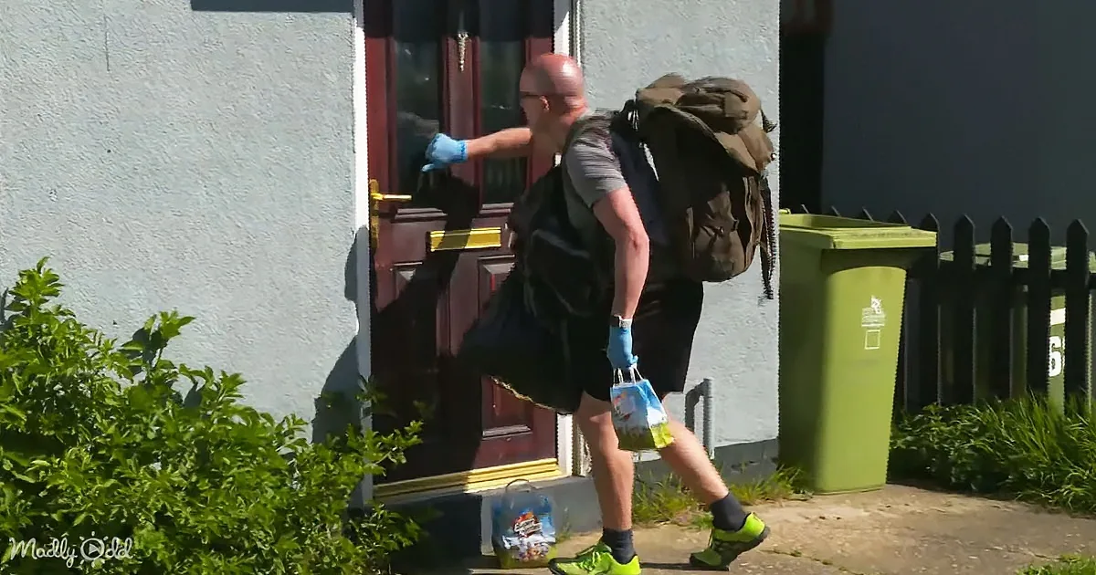 A man in shorts and gloves carries a bag, wearing a backpack, and敲门。