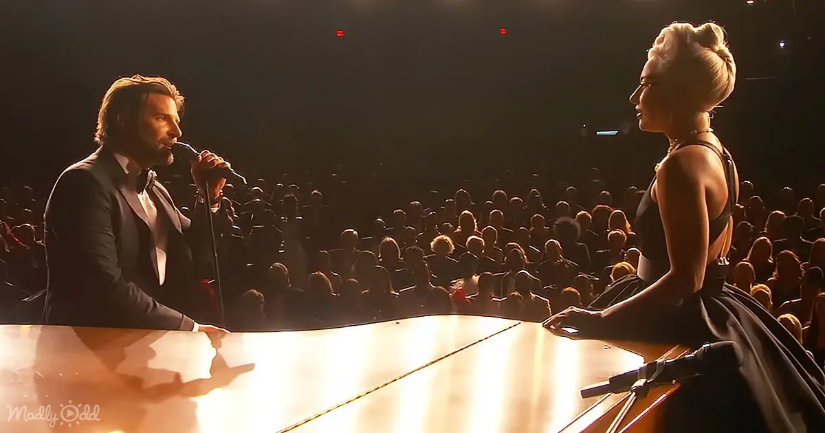 Bradley Cooper and Lady Gaga perform on stage in front of a large audience.