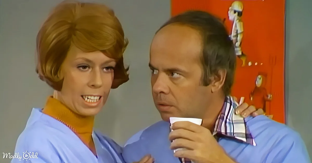 A man in a striped shirt holds a cup, while a woman with red hair smiles beside him.