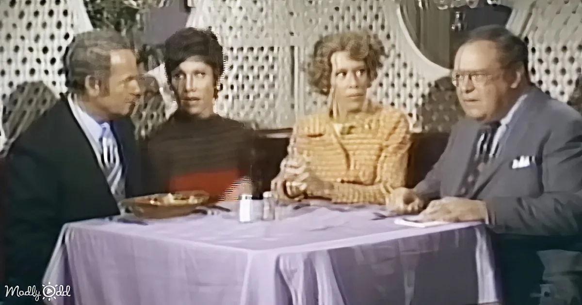 Four individuals seated at a table with a purple tablecloth, engaged in conversation.