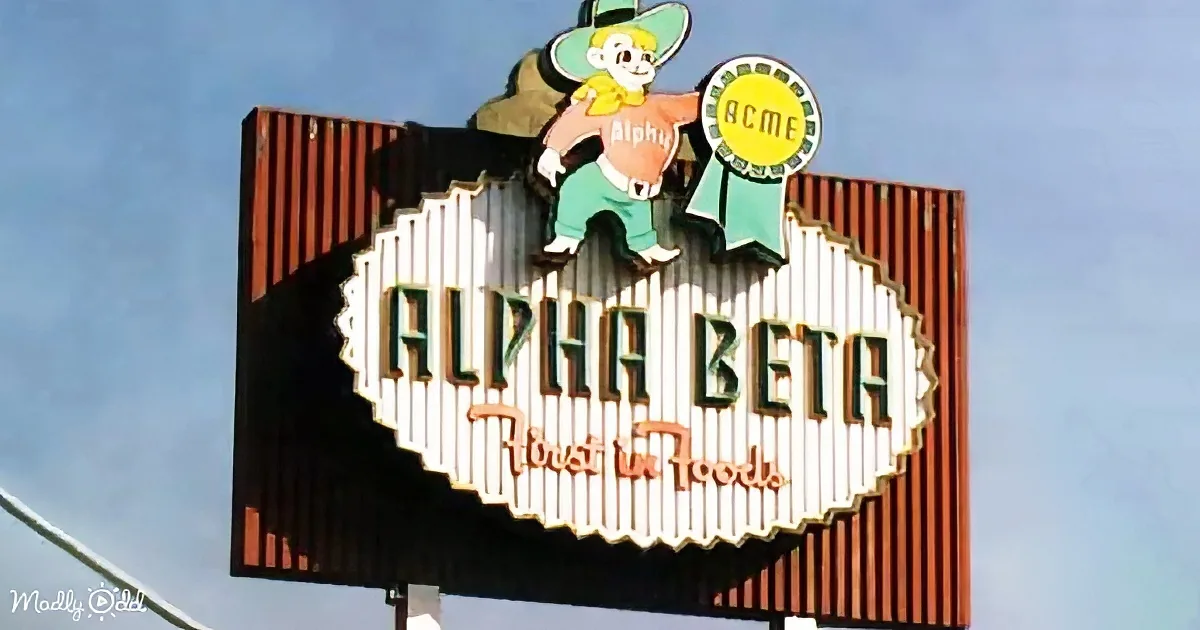 A vintage Alpha Beta grocery store sign with a cartoon character and "Trust in Foods" slogan.