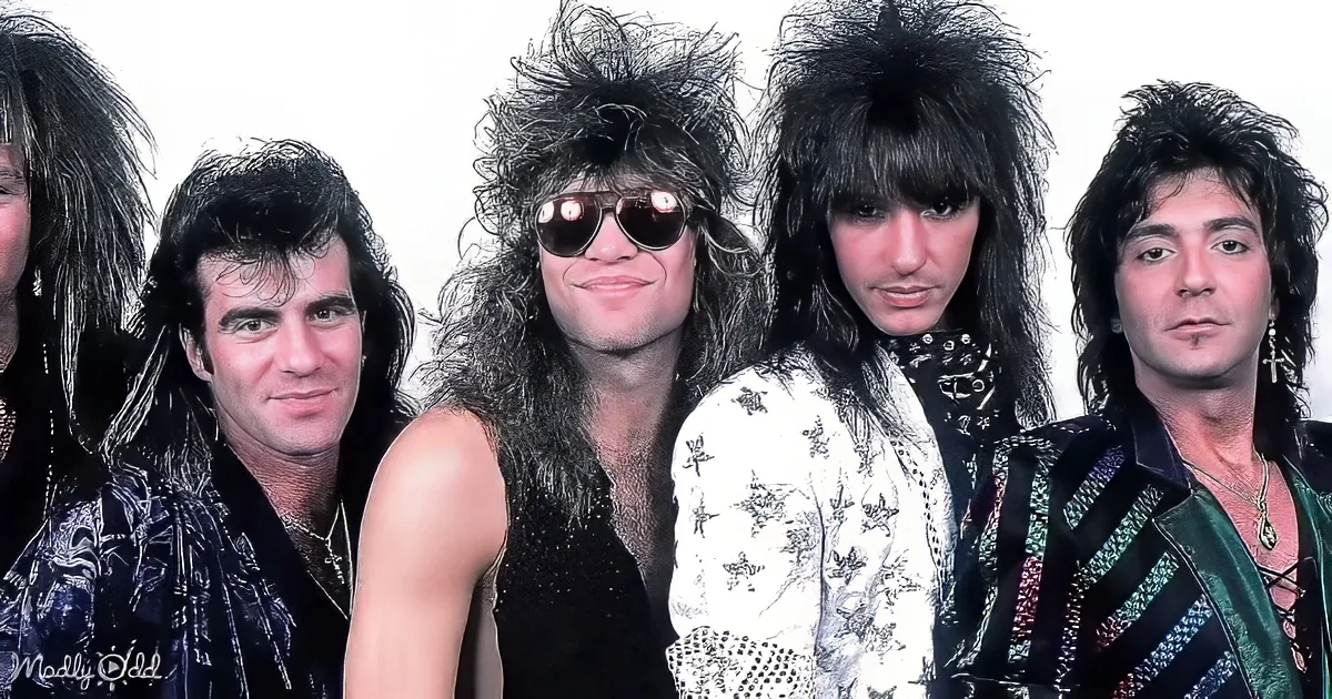 Five individuals with 80s rock star hair styles and bold fashion posing together.