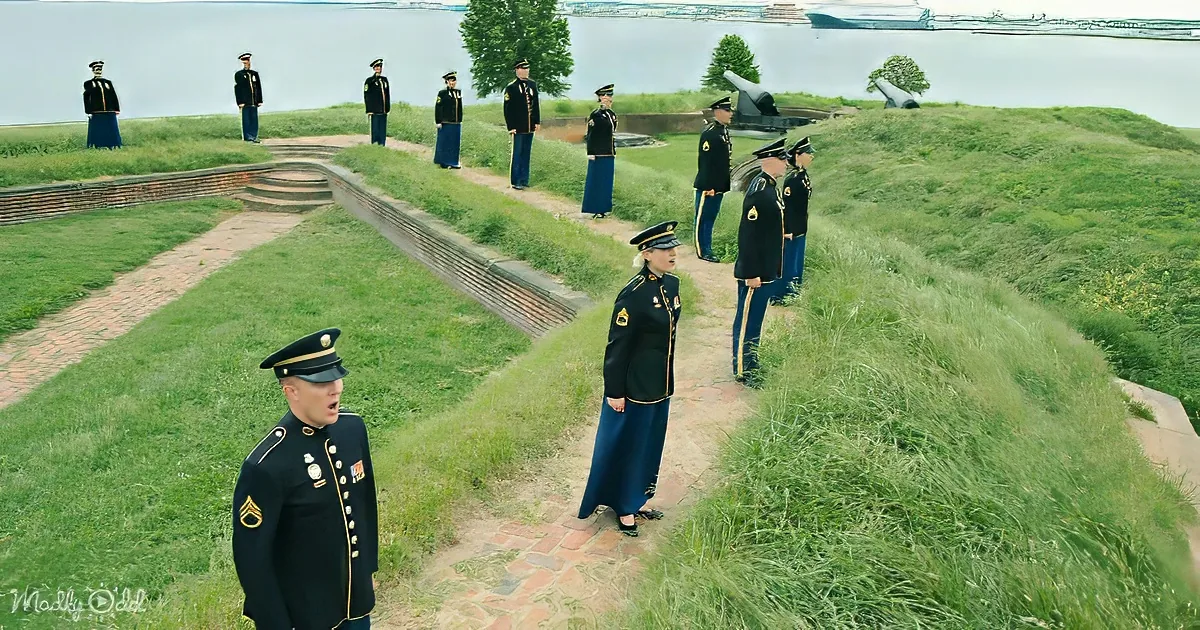 A group of uniformed individuals in a grassy area with a brick pathway, possibly a ceremonial or military setting.