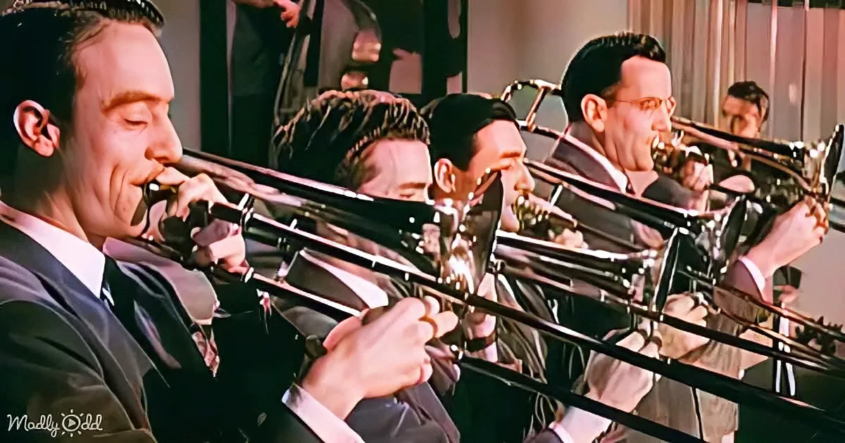 A group of musicians in suits play trombones in a synchronized formation.