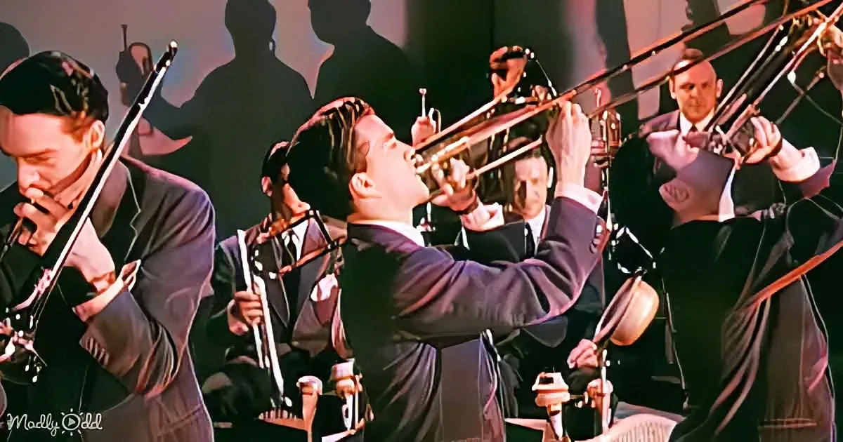 A man in a suit passionately plays a trumpet in a jazz band setting.