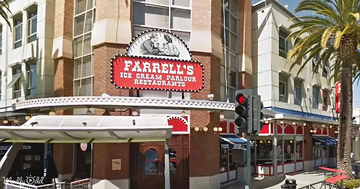 Farrell's Ice Cream Parlour and Restaurants sign atop a brick building with palm trees and outdoor seating.