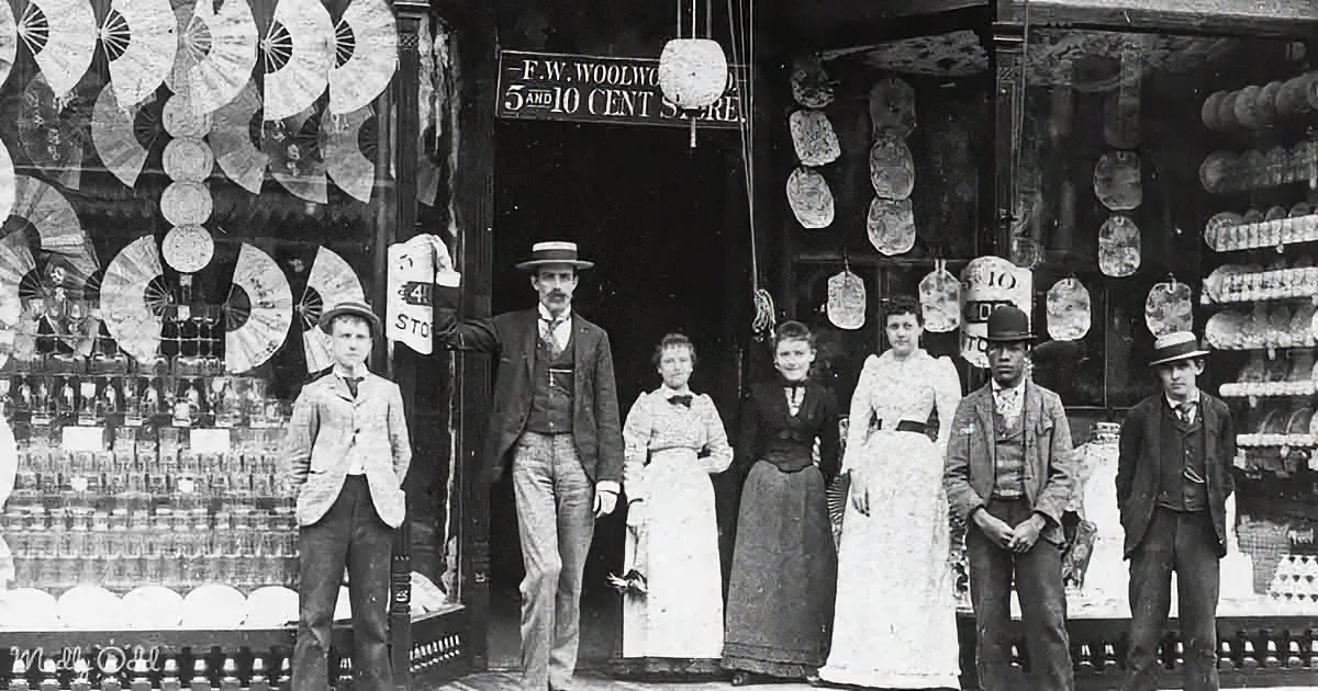 Group of people in front of F.W. Woolworth's 5 and 10 Cent Store with vintage merchandise and fans in the window.