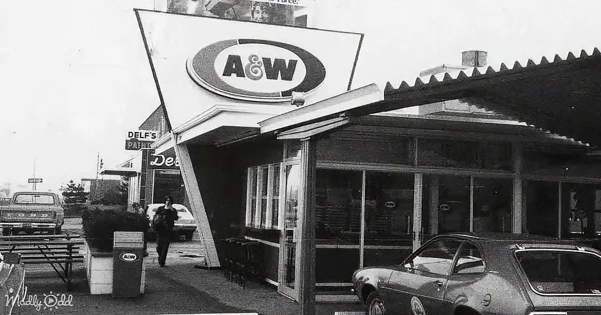 A&W restaurant with retro design, cars parked, person walking, and sign above entrance.