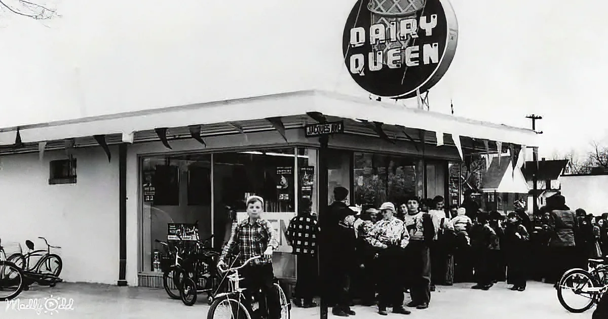 A Dairy Queen ice cream shop with a crowd of people and bicycles outside.