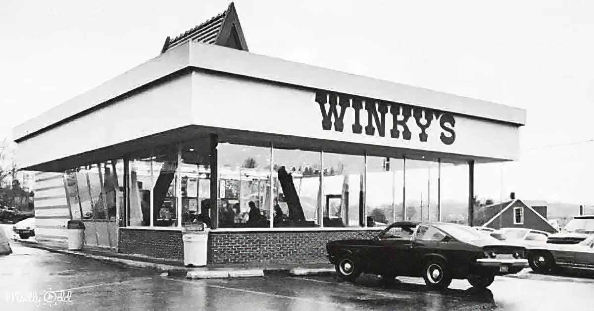Winky's, a vintage diner with a brick facade and large windows, is seen in a black-and-white photo.