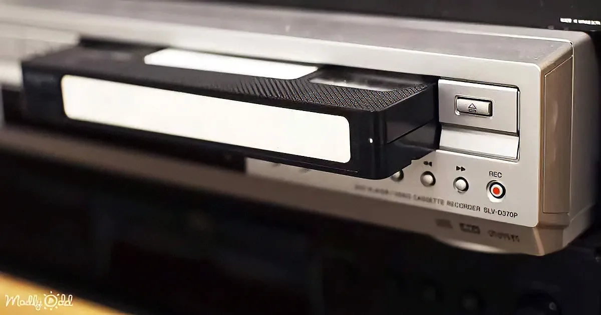A close-up of a silver cassette recorder with a cassette partially inserted and controls visible.
