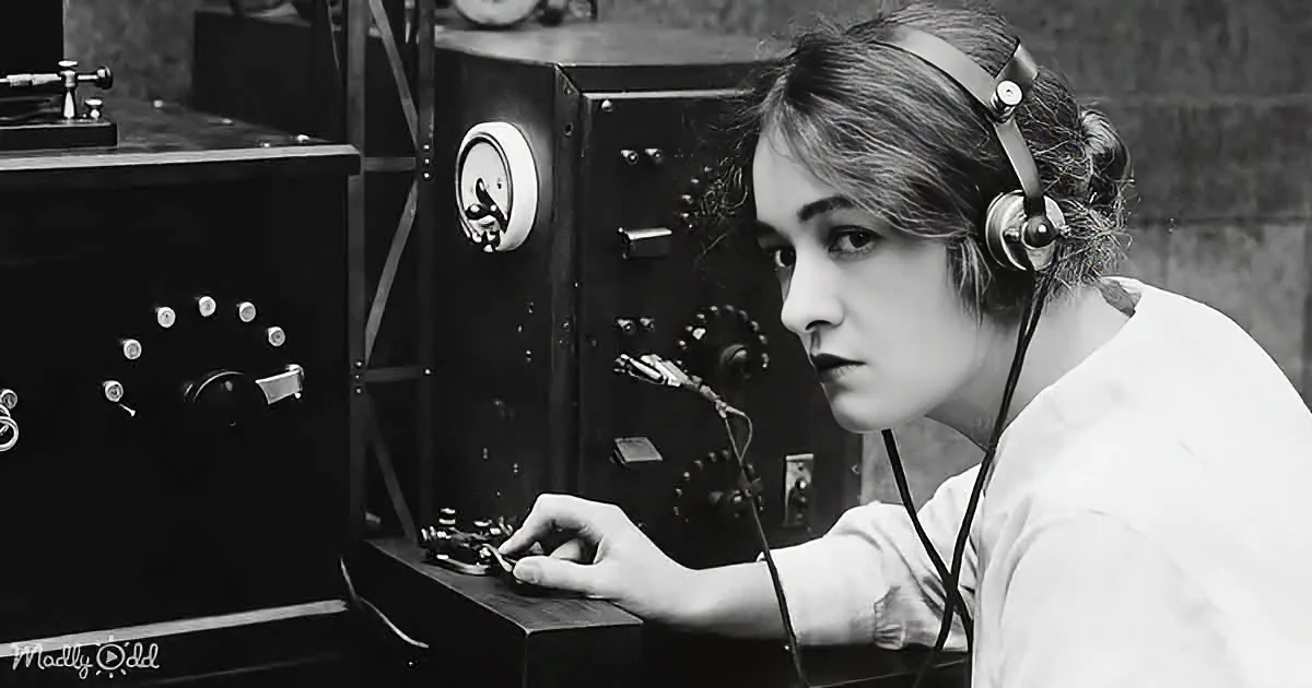 A woman wearing headphones operates a vintage radio or communication device with dials and switches.