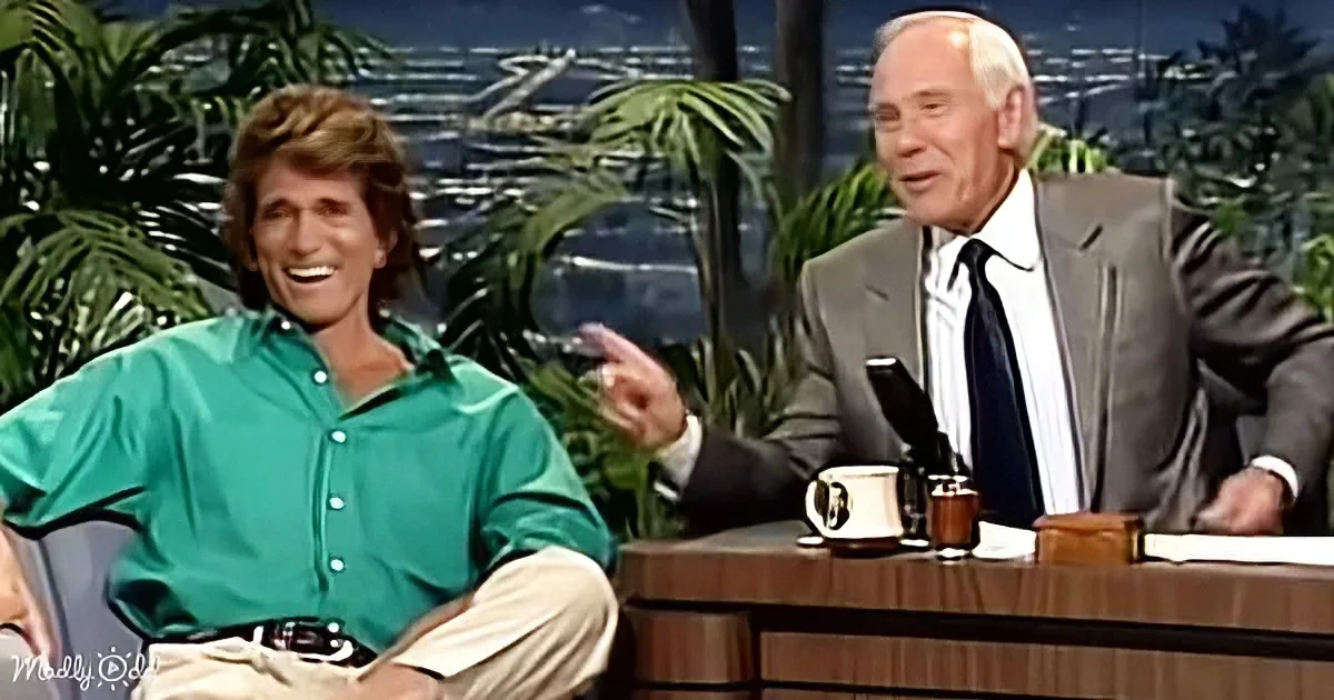 A man in a green shirt is gesturing animatedly while sitting on a talk show set.