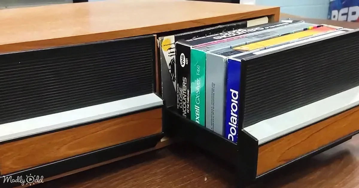 A vintage VHS tape storage unit with "Close Encounters" and "Polaroid" tapes inside.