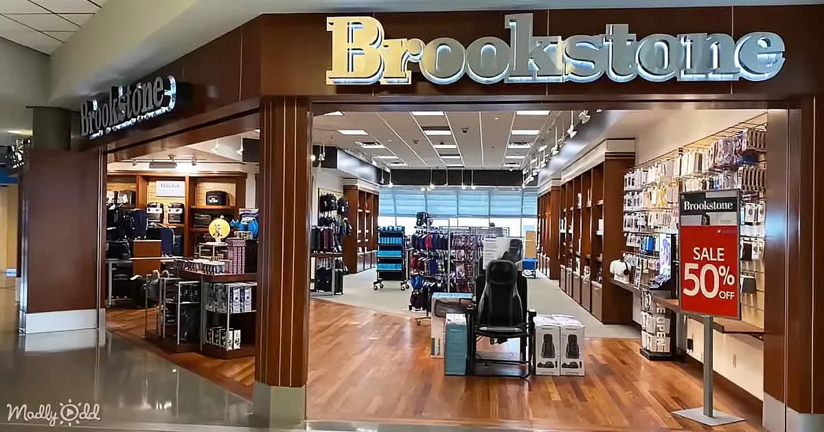 Brookstone store entrance with sale sign, wooden floor, and various products displayed inside.