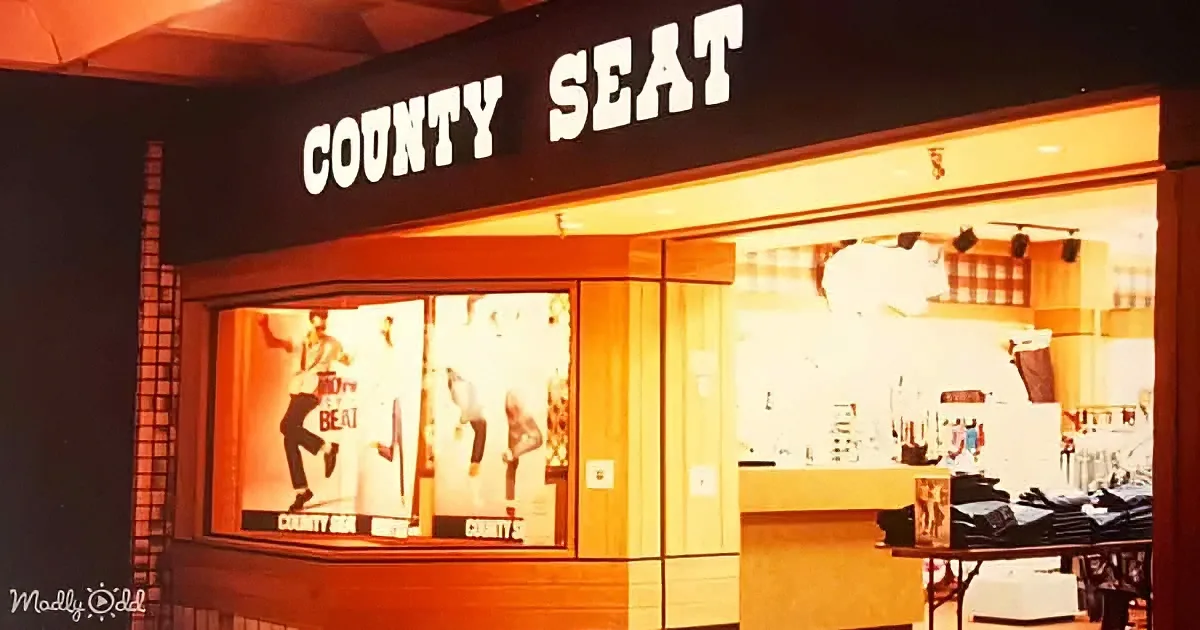 A vintage "COUNTY SEAT" store with illuminated windows displaying men's clothing and posters.