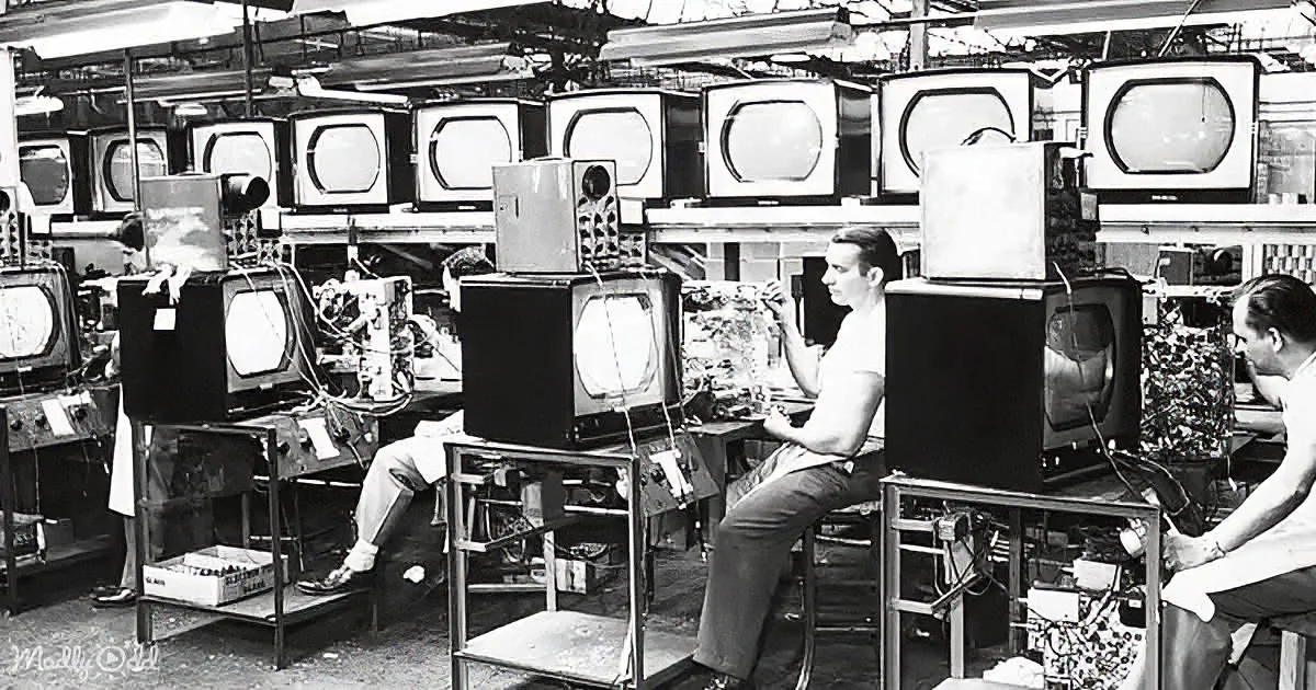 Workers assemble vintage TVs in a factory setting with multiple screens and equipment.