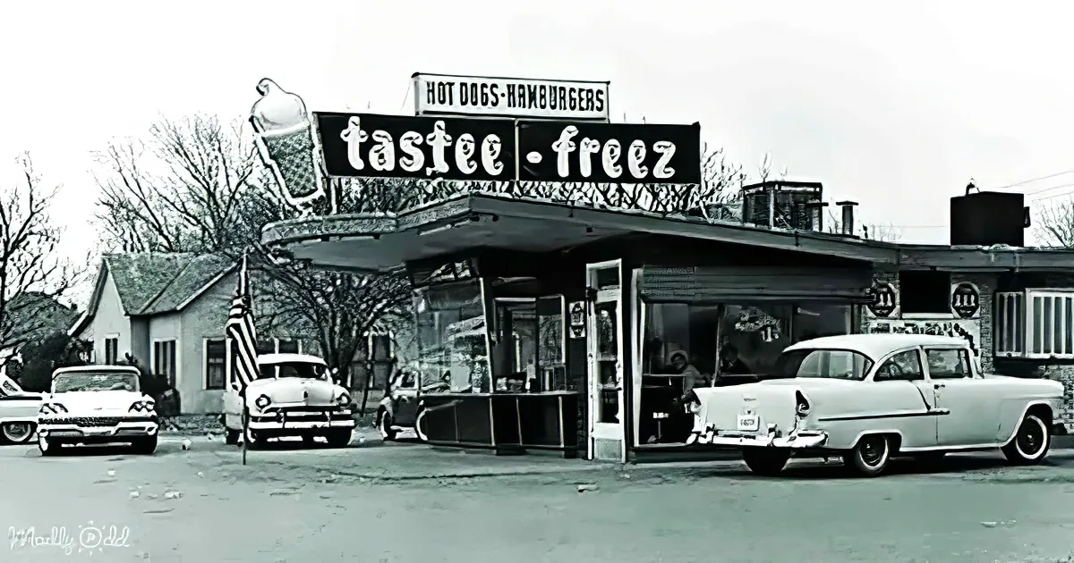 Tastee-Freez diner with vintage cars and ice cream sign, nostalgic 1950s scene.