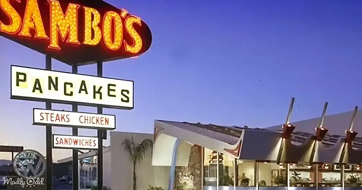 A vintage Sambo's restaurant sign advertises pancakes, steaks, chicken, and sandwiches under a clear blue sky.