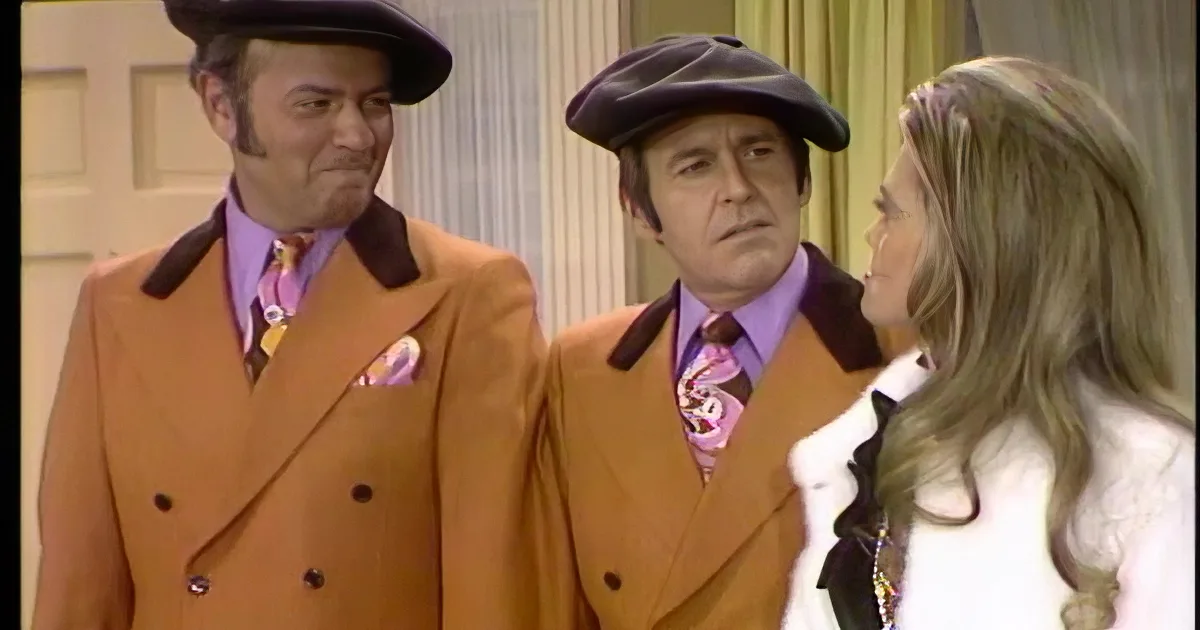 Four people in vintage attire smile and laugh together in a warmly lit room.
