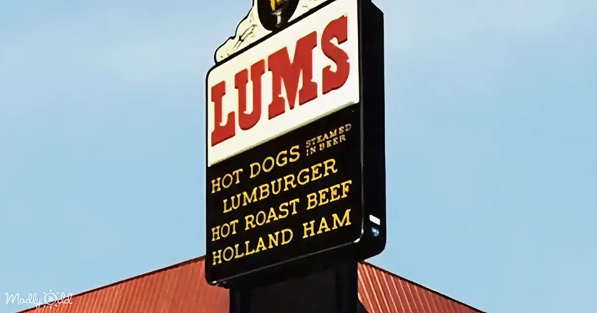 A sign for "LUMS" advertises hot dogs, lumburger, hot roast beef, and Holland ham.