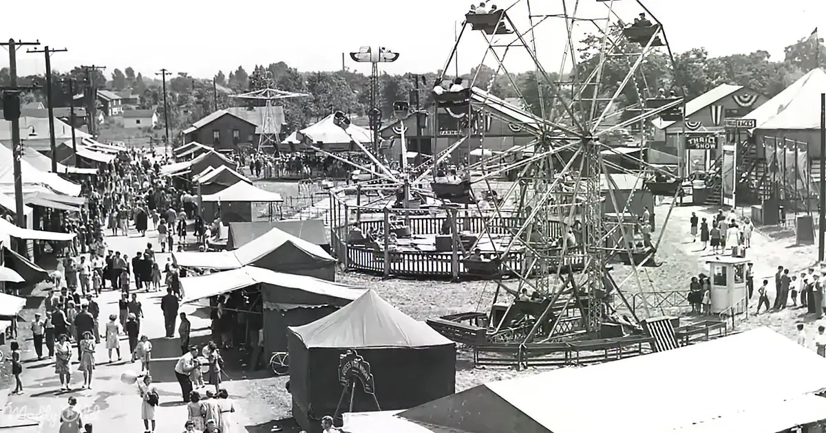 A bustling fair with a large Ferris wheel, various tents, and crowds enjoying rides and activities.