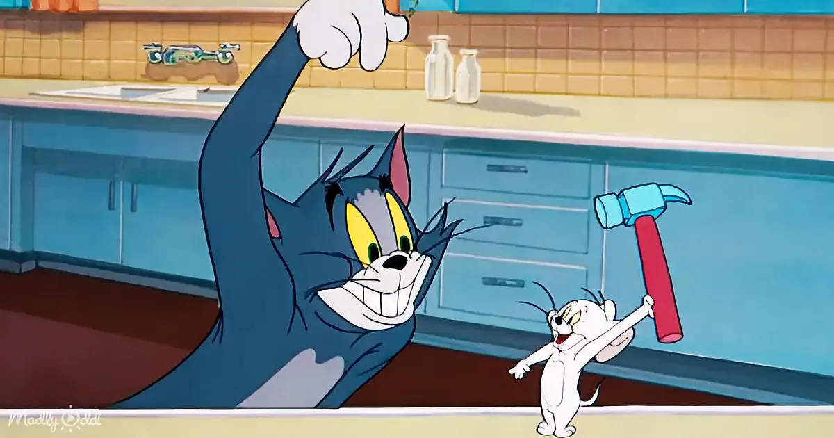 Tom, the cat, is in a kitchen, raising his paw, while Jerry, the mouse, holds a hammer, both appearing playful.