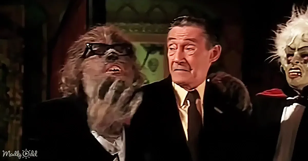 A man in a suit stands between two costumed characters, one with a furry head and glasses, the other with a white, spiky...