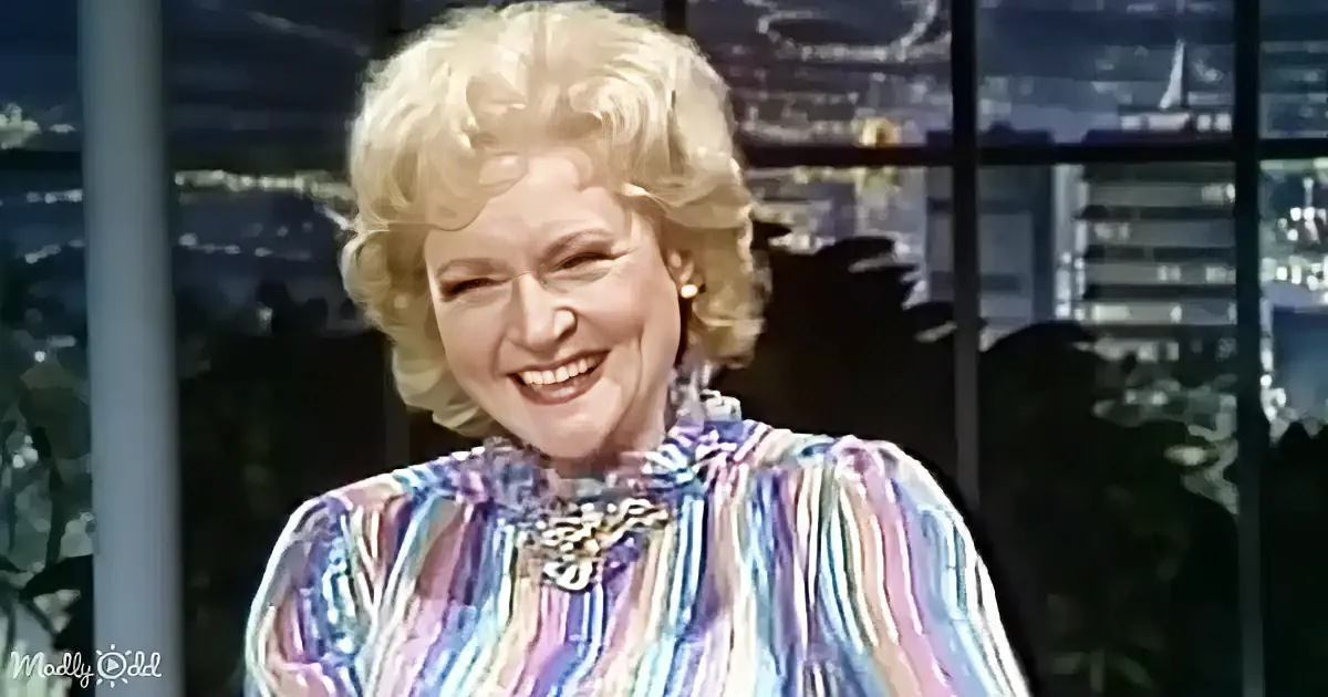 A smiling woman with blonde, curly hair in a colorful striped shirt is the main subject.