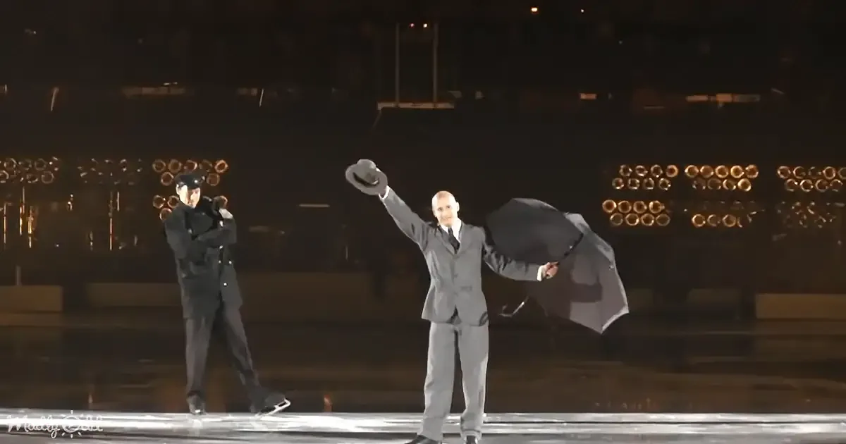 A man in a suit holds a hat and umbrella, standing on ice, with another figure in the background.