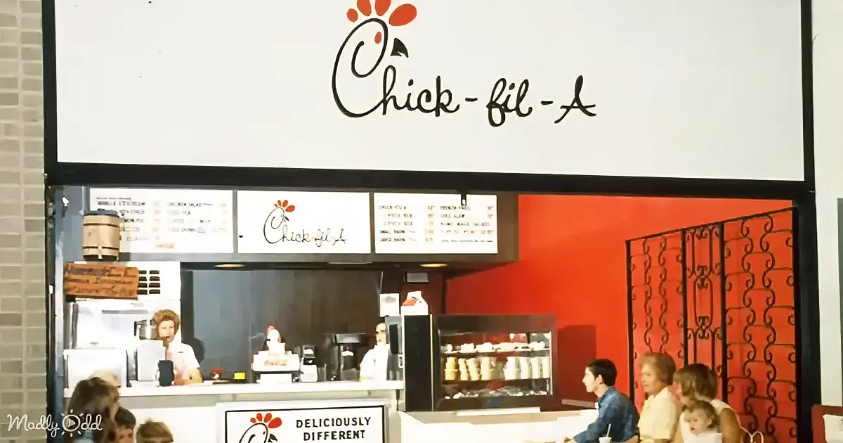 Chick-fil-A restaurant with menu boards, counter, and customers inside.