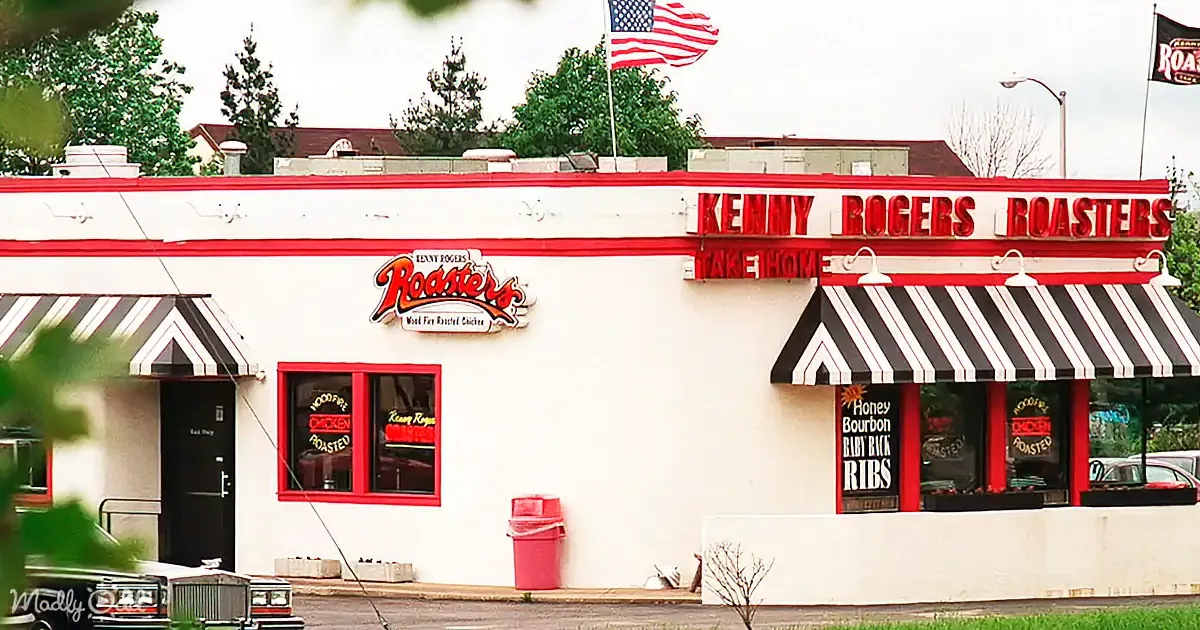 Kenny Rogers Roasters restaurant with red and white signage, black and white striped awnings, and American flag flying.
