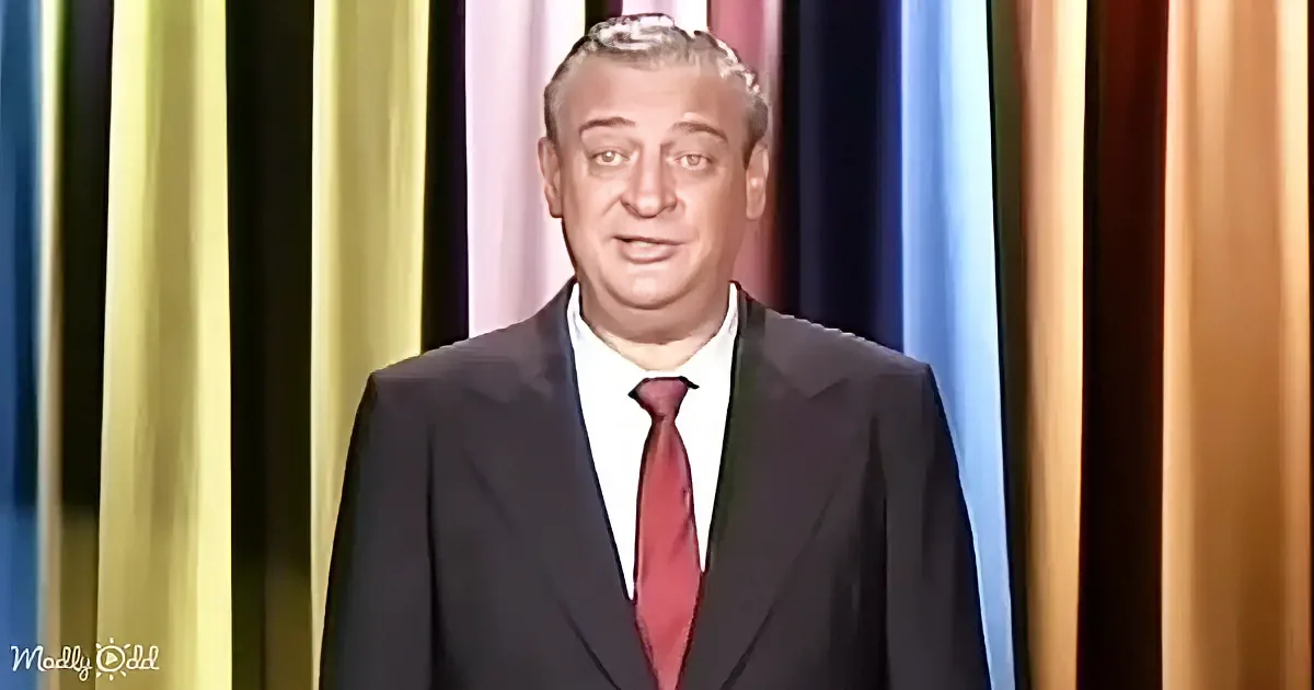 A man in a suit and red tie stands in front of a colorful striped background.