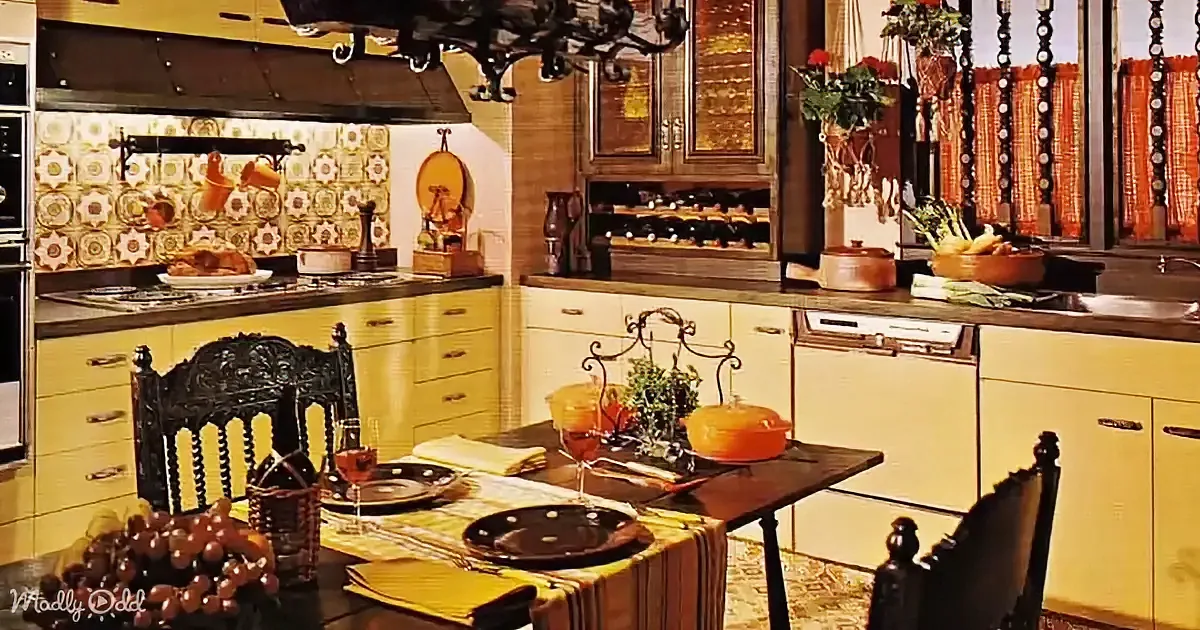 A vintage kitchen with yellow cabinets, ornate chairs, and a chandelier, featuring a dining table set for a meal.