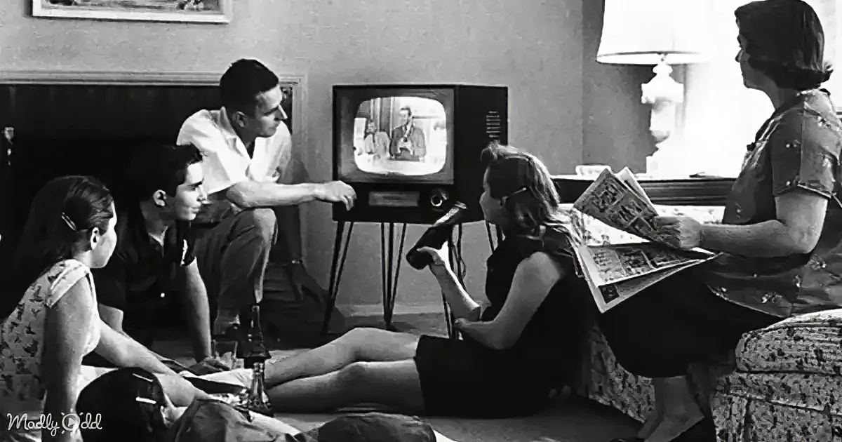 A family gathers around a vintage television in a cozy living room, watching a program together.