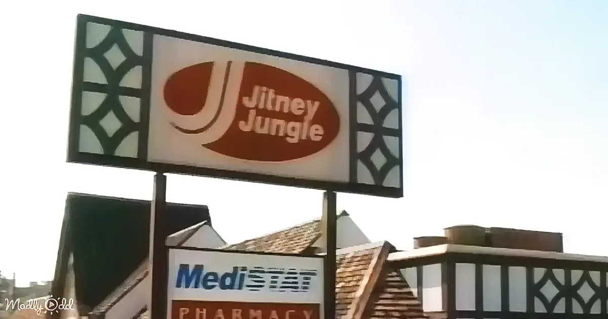 A sign for "Jitney Jungle" with a stylized "J" logo is prominently displayed against a clear sky.