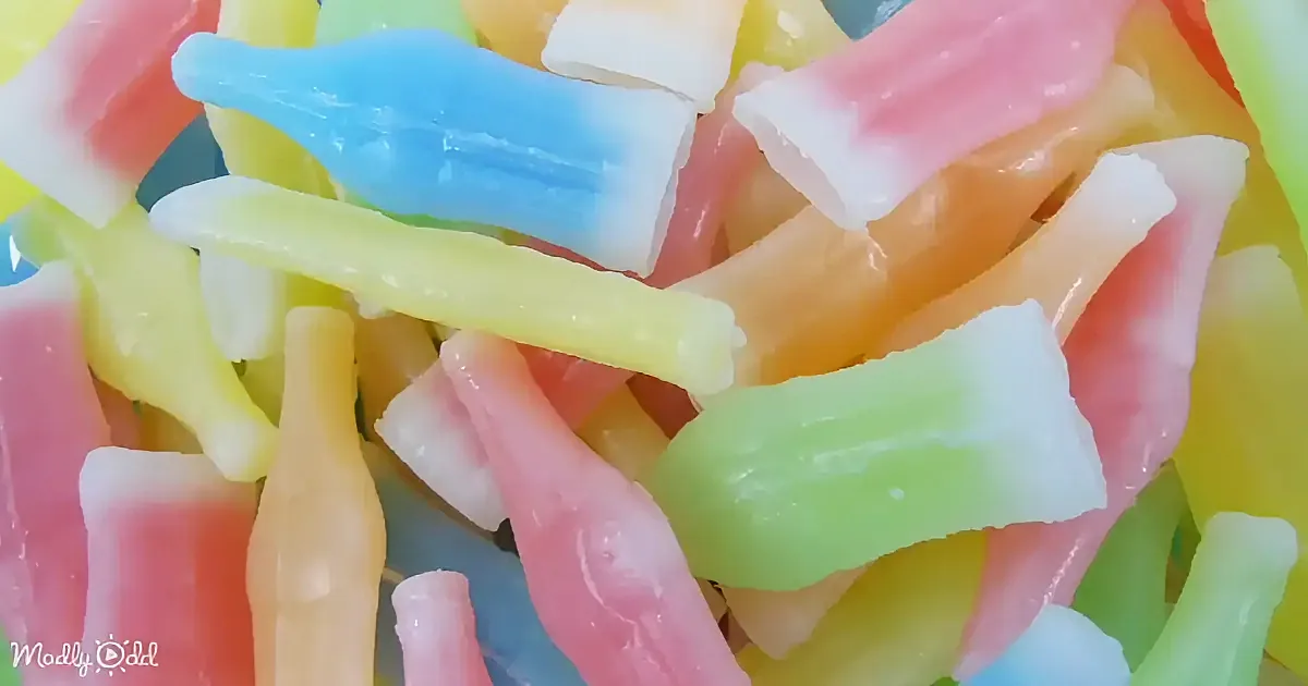 Colorful, translucent gummy candies in various shapes and vibrant hues are scattered together.