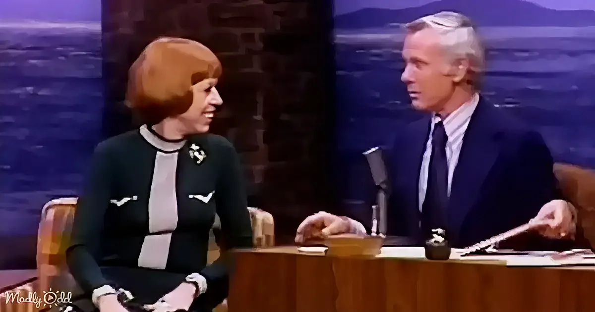 A woman in a green and white outfit sits next to a man in a suit on a talk show set.
