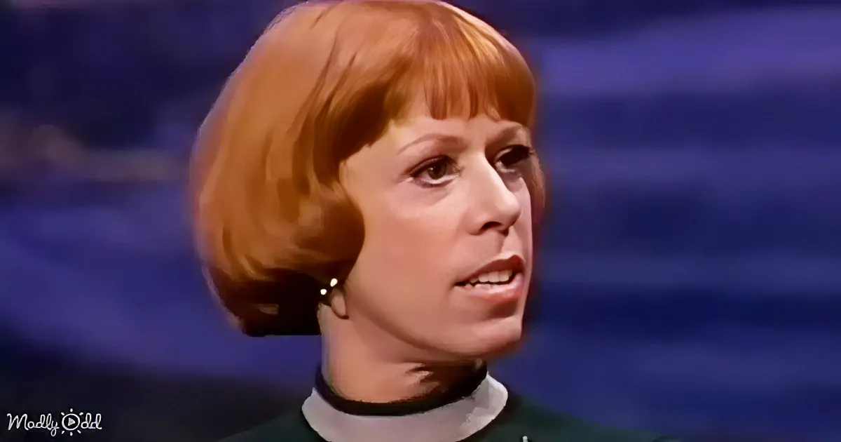 A woman with short, reddish-brown hair and a green top is shown in a close-up shot.